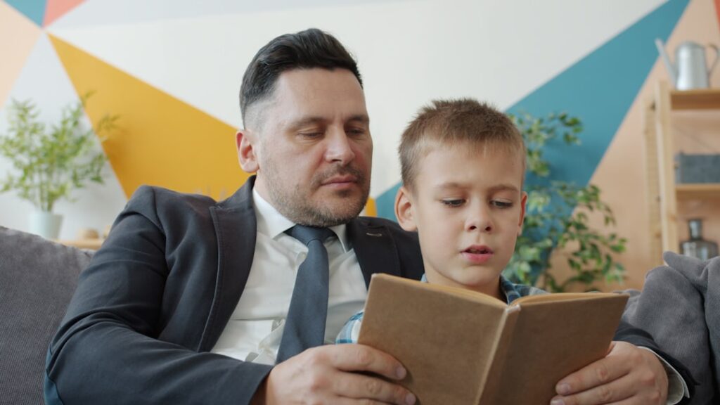 Reversão de Guarda Compartilhada: Entenda e Solicite - Robison Souza - Perito em Psicologia Forense Pai E Filho Lendo Um Livro Juntos RpFdBLE9tQQ