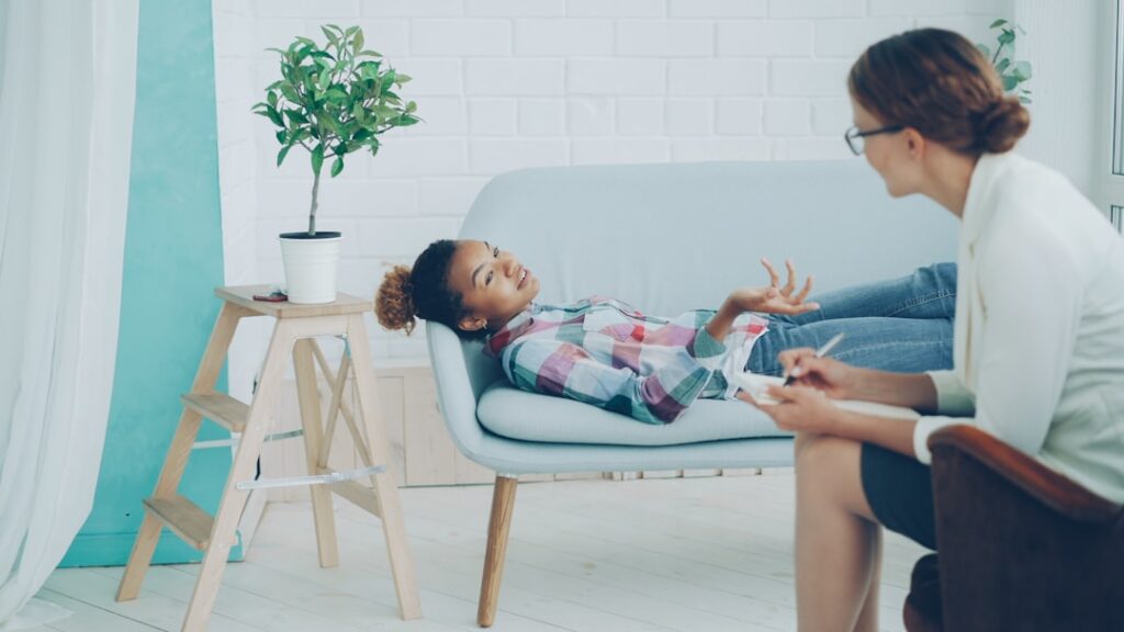 O que é Psicologia Forense Infantil? - Robison Souza - Perito em Psicologia Forense Uma Jovem Conversa Com Um Terapeuta Em Um Sofa ObIW_W6jnXg