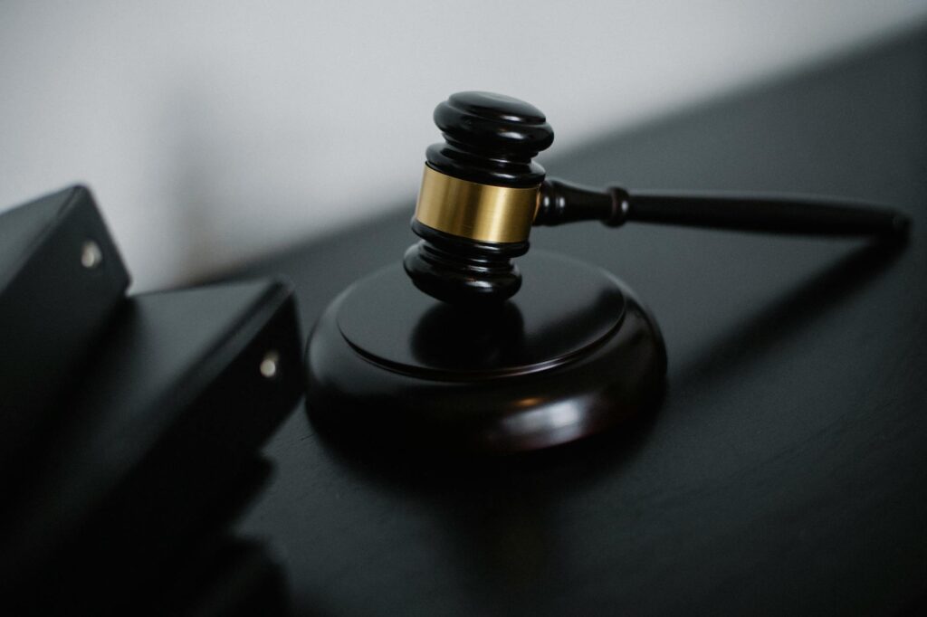 Alienação parental é crime qual a pena - Robison Souza - Perito em Psicologia Forense High angle of shiny wooden ceremonial mallet with golden detail placed on judge tale near documents folders