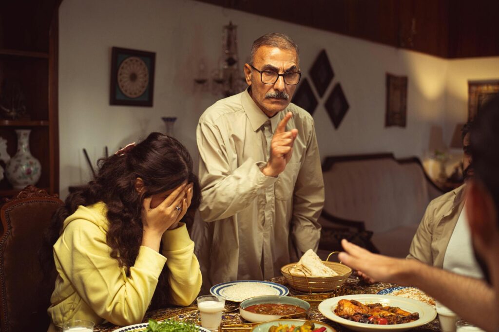 O que se enquadra em alienação parental - Robison Souza - Perito em Psicologia Forense A tense moment with a family disagreement at the dinner table indoors.