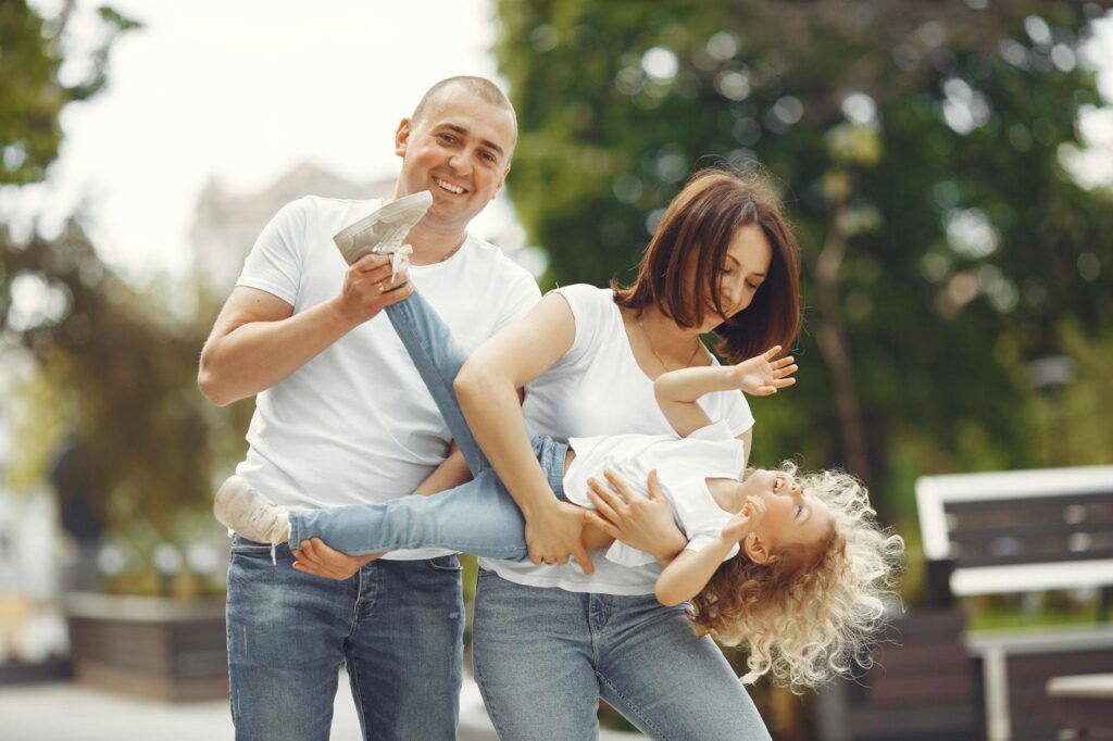 Como entrar com alienação parental - Robison Souza - Perito em Psicologia Forense Happy family enjoying playful moments outside on a sunny day.