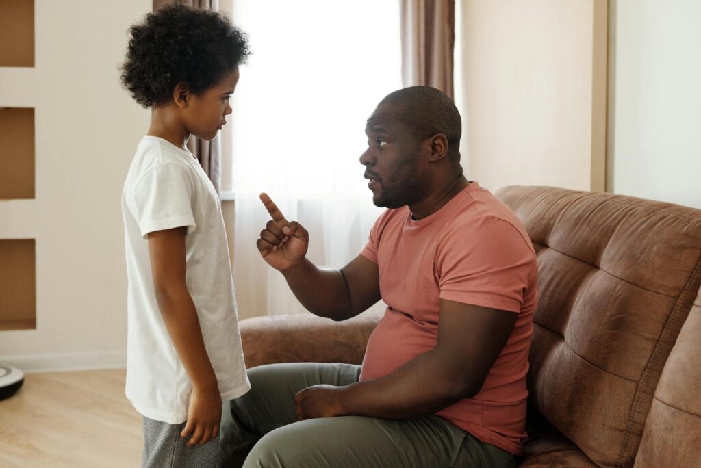 Como identificar alienação parental - Robison Souza - Perito em Psicologia Forense Father and son engaged in a heartfelt conversation on the sofa, illustrating parenting in a loving family setting.