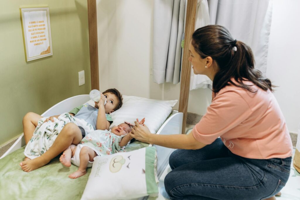 Como reverter alienação parental - Robison Souza - Perito em Psicologia Forense A mother sits with her children on a bed, fostering a warm and nurturing atmosphere.