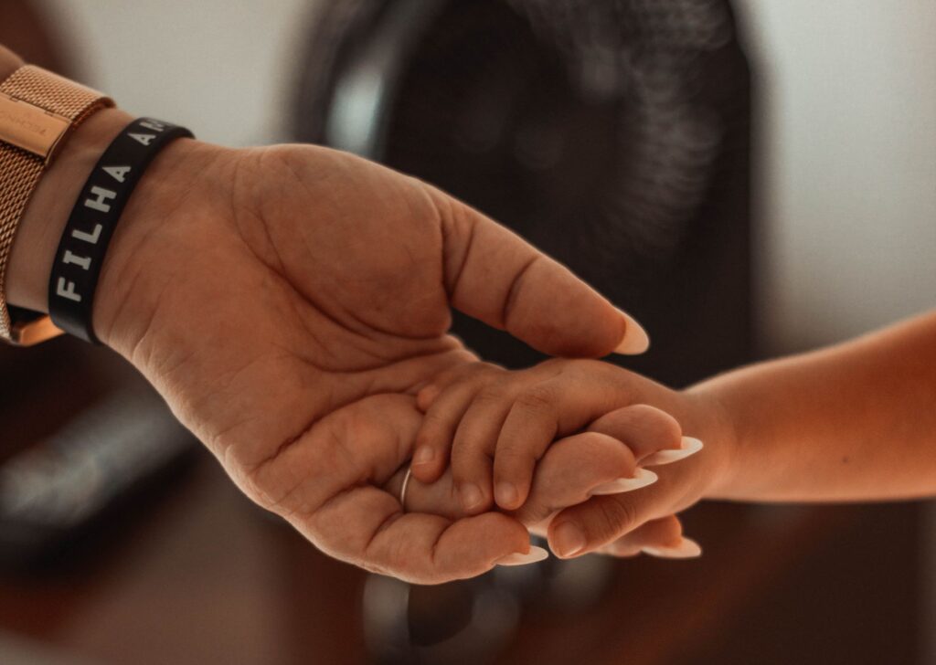 O que é alienação parental psicologia - Robison Souza - Perito em Psicologia Forense Emotional close-up of a parent and child holding hands, showing connection and love.
